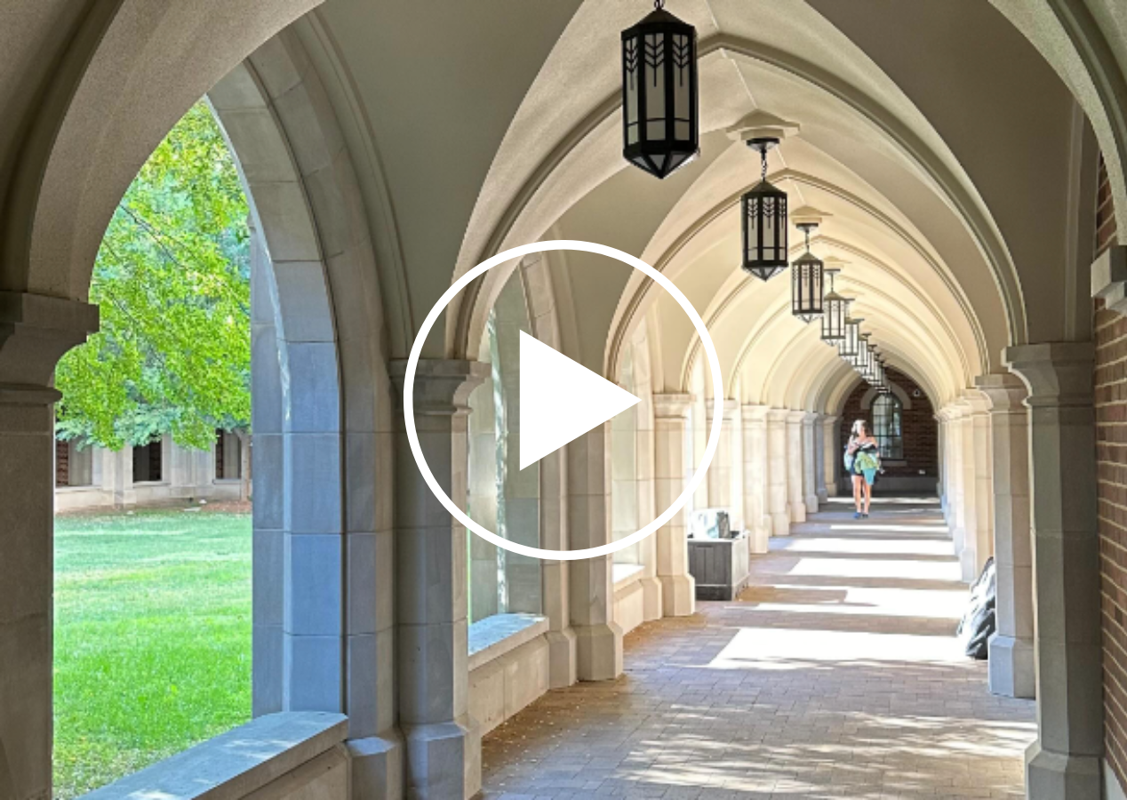 Video still showing a student walking between buildings on campus.