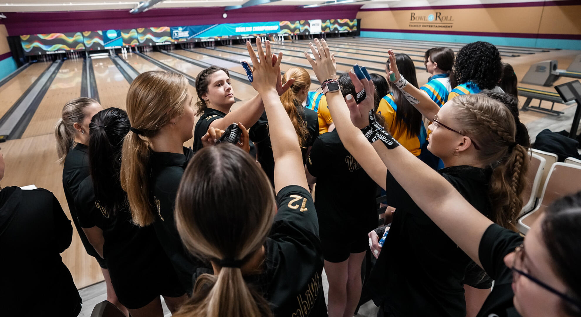 Vanderbilt bowling team members pile their hands together during a Regional Finals match.
