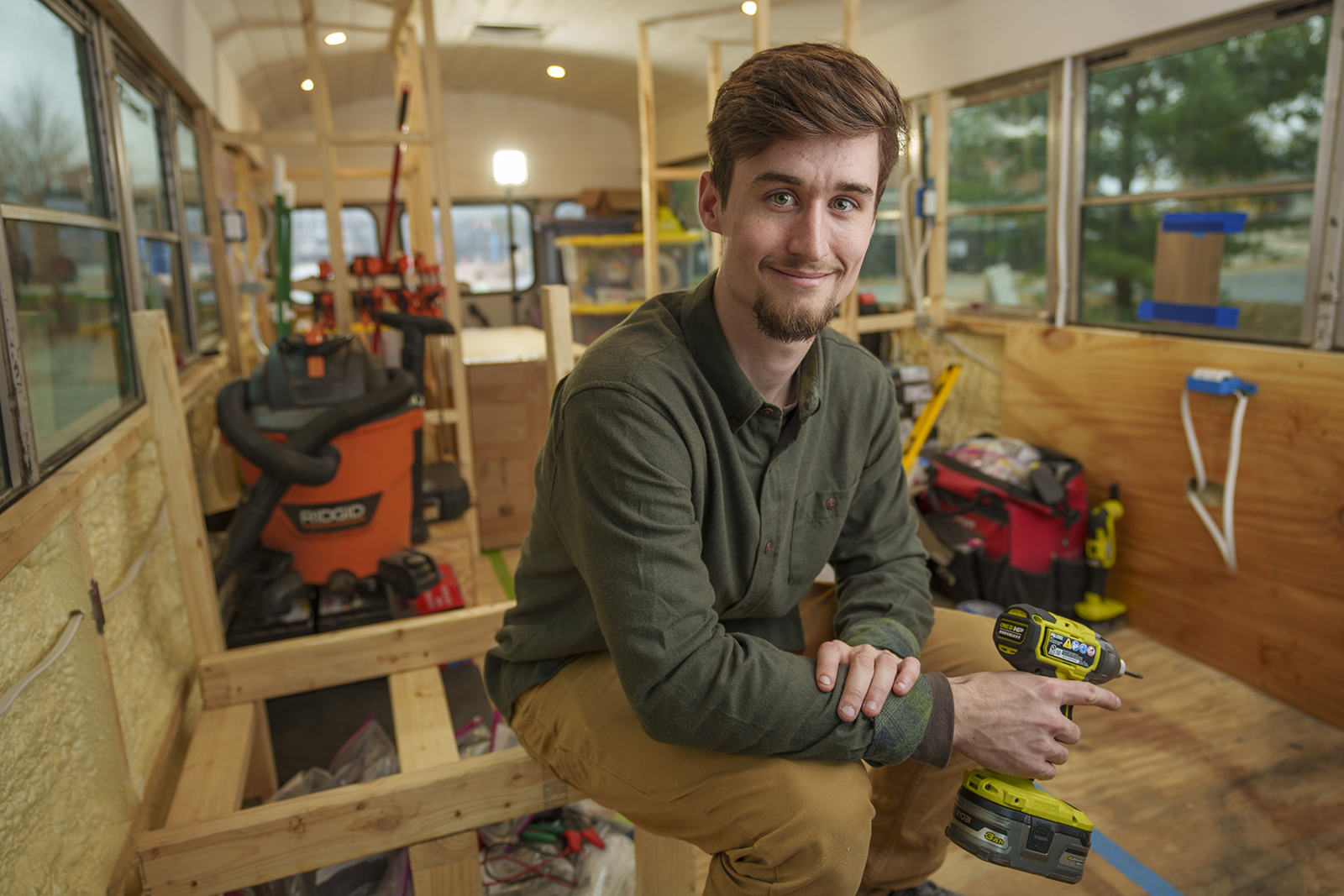A student poses with power tools and a drill.
