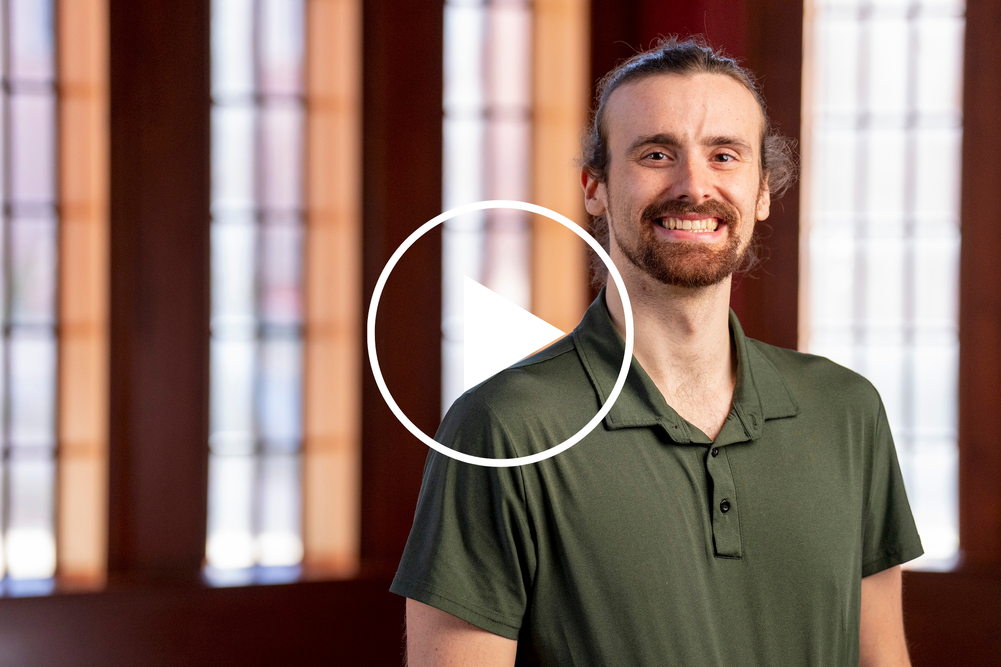 Headshot of Dan Russell with white play button indicating a video.