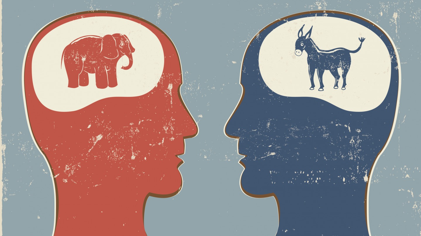 To heads, the left one red with an elephant in the "brain area," and the right blue with a donkey, face each other.