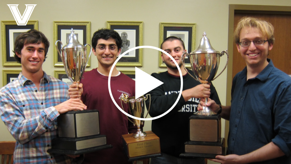 Screengrab of Vanderbilt Debate video featuring four Debate members holding trophies