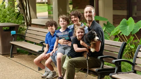Robin Michael Jones, associate professor of hearing and speech sciences, with his wife, Kristin, their children Arlo, Bodhi and Leona, and their puppy, Pawley (Harrison McClary/Vanderbilt University)