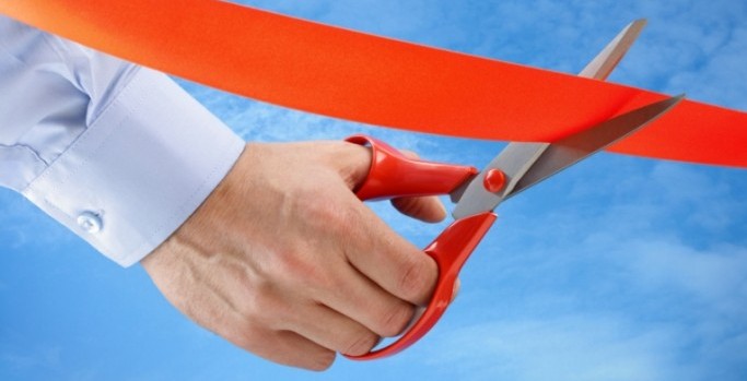 concept of scissors cutting red ribbon