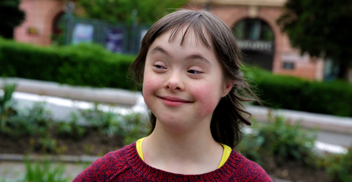 smiling caucasion girl who has down syndrome