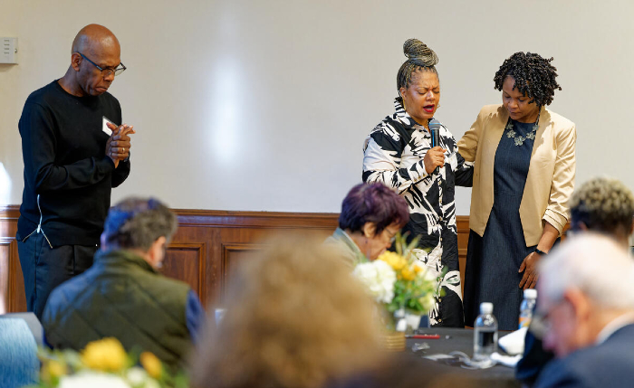 Bishop Joseph W. Walker III (left) and Pastor Catina Parrish-Clark (center), both of Mt. Zion Baptist Church and Vanderbilt Divinity School alumni, pray with Dean Yolanda Pierce (right) at the Divinity School breakfast event on Sept. 19. (Harrison McClary/Vanderbilt)