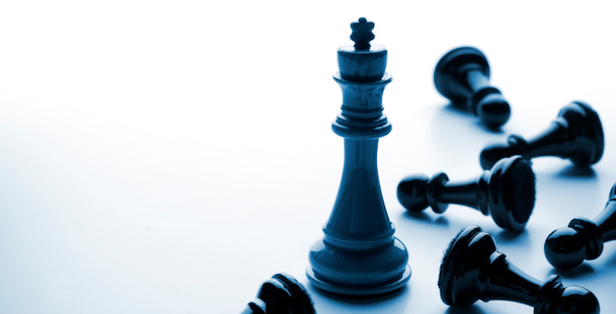 Black chess king surrounded by fallen black pawns