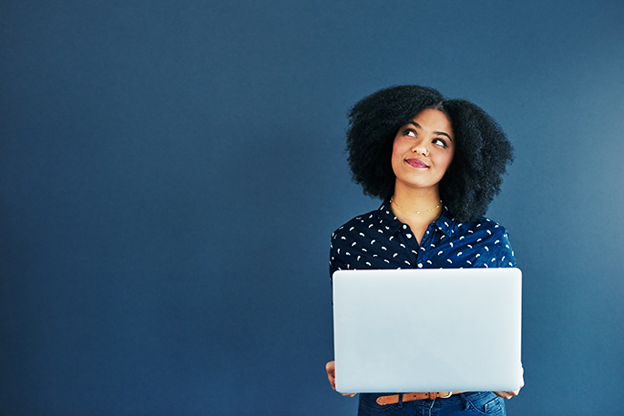 Woman with laptop looks upward, considering her options.