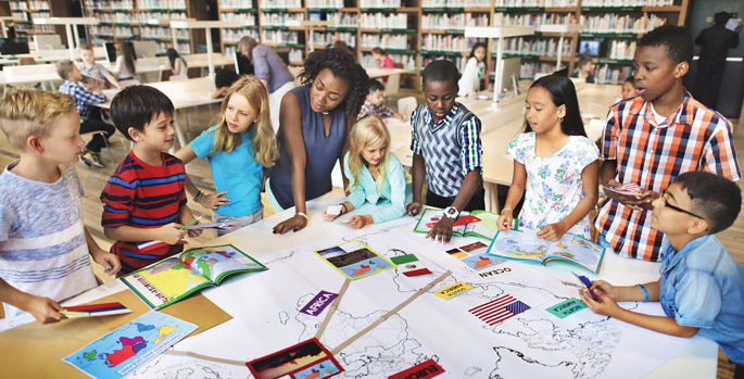 African American woman teacher working with diverse students in a school library