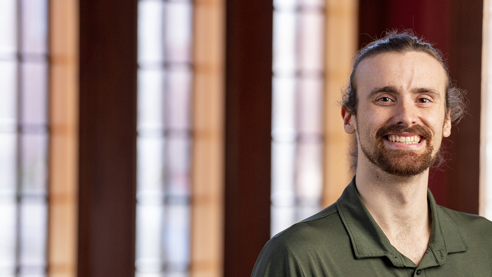 Dan Russell, wearing a green shirt, against the backdrop of windows