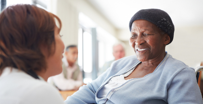 A caregiver talking to a wheelchair-bound patient
