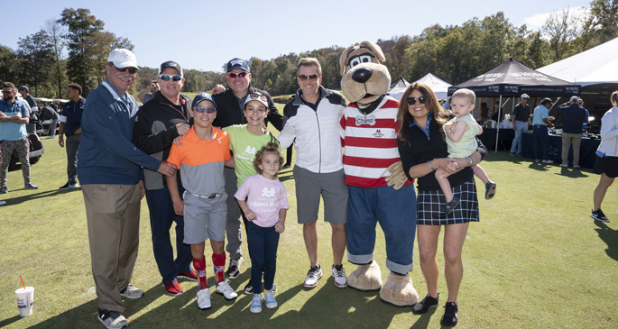 Rascal Flatts members kick off the fourth-annual Rascal Flatts Celebrity Golf Classic with Children’s Hospital patient ambassadors, event sponsors and Champ, the hospital’s mascot. Shown here are patient ambassadors Logan Miller, Jessica Meyer, Caroline Lantz, and Levi Ray (in front) with, from left, Delta Dental’s Phil Wenk, Gary LeVox, Jay DeMarcus, Joe Don Rooney, Champ, WME’s Kristin Cantrell.