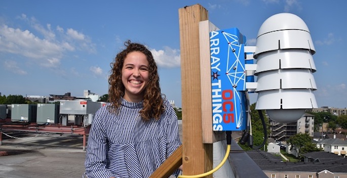 portrait on roof with sensoring device mounted on pole that looks like stacked hard hats