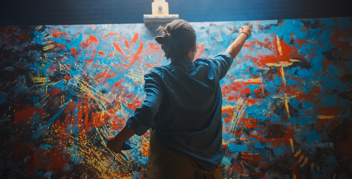 Woman Artist Works on Abstract Oil Painting, Using Paint Brush She Creates Modern Masterpiece. Dark and Messy Creative Studio where Large Canvas Stands on Easel Illuminated. (Talented Female Artist Works on Abstract Oil Painting