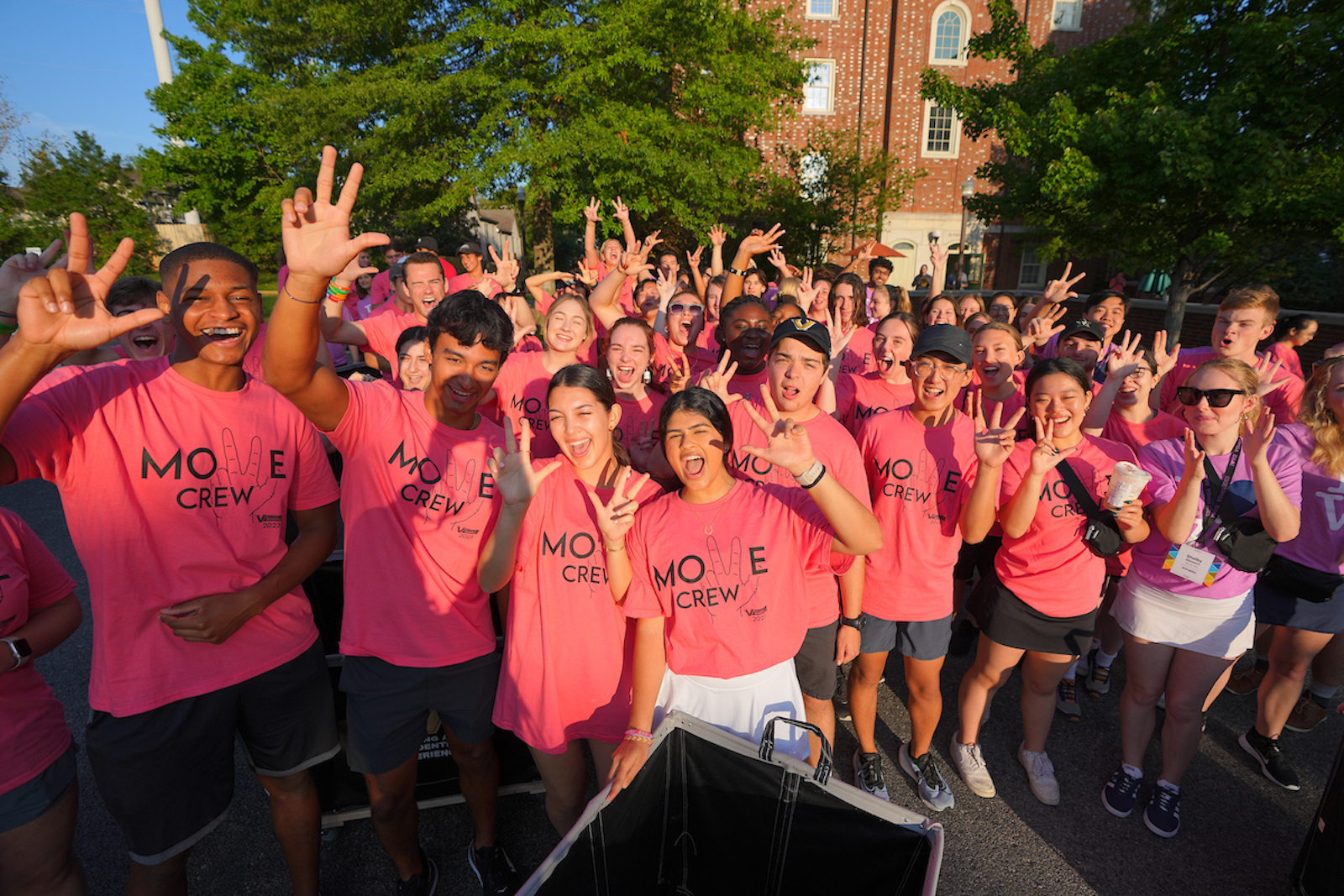 Move Crew members throw the VU hand sign while getting ready to help incoming students move in