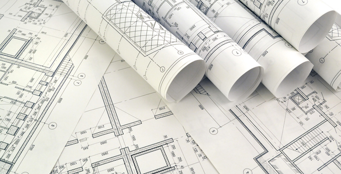 Photo of rolled-up blueprints on drafting desk