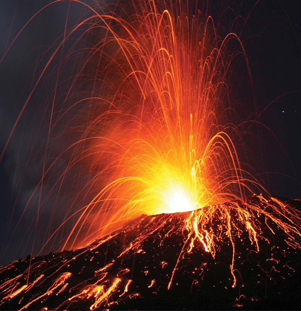 photo of a volcano erupting at night