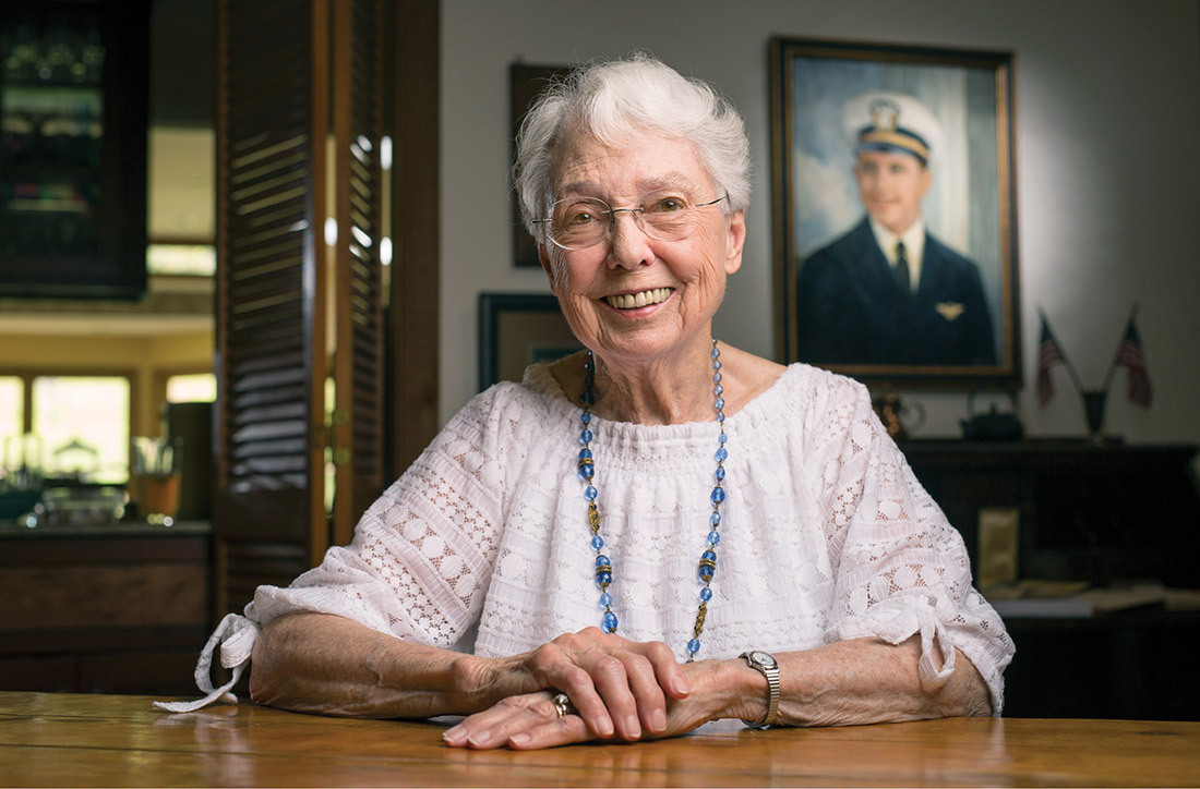 Emily Manchester Townes, BA’50, has preserved her brother’s war letters by compiling them into a family history. A portrait of John Manchester hangs behind her. (DANIEL DUBOIS)