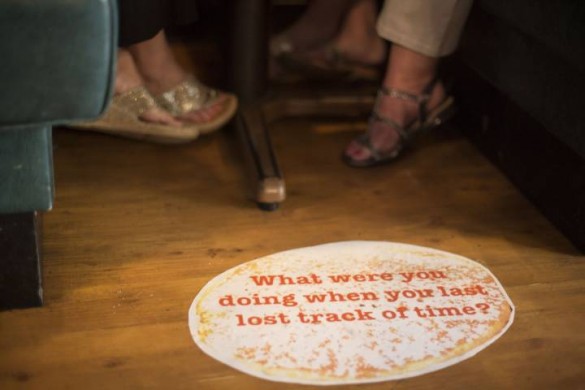 Mel Ziegler class art project in Hillsboro Village image of pancake on floor with words What Were You Doing The Last Time You Lost Track Of Time?