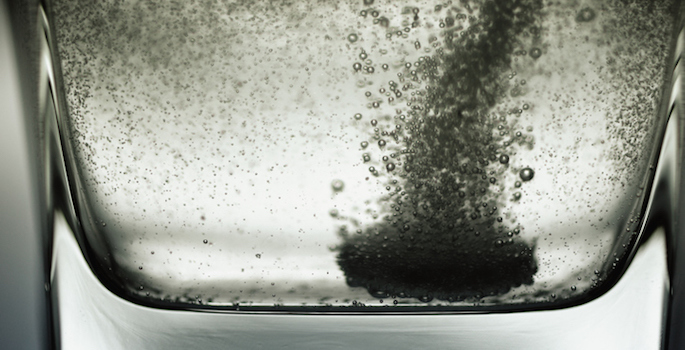 effervescent heartburn tablet fizzing in clear glass of water