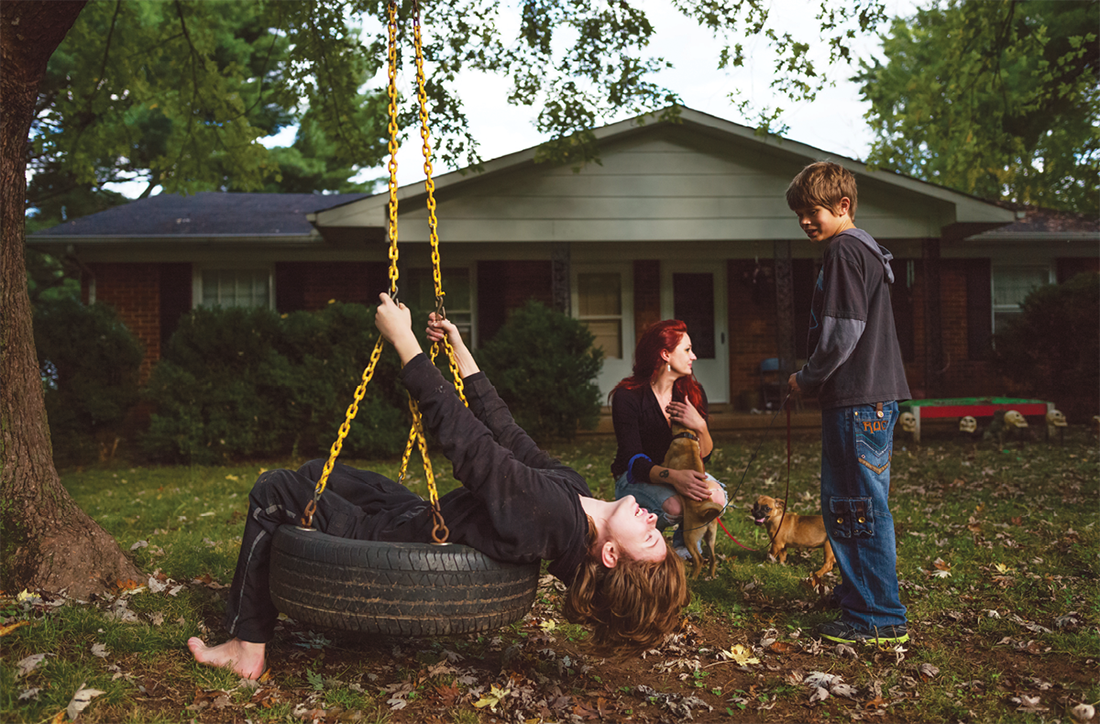 Photo of family playing in front of house