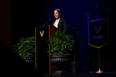 A woman standing before a podium in an auditorium