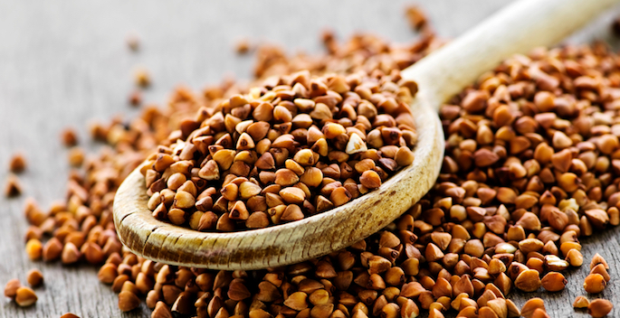 Buckwheat seeds on wooden spoon in closeup