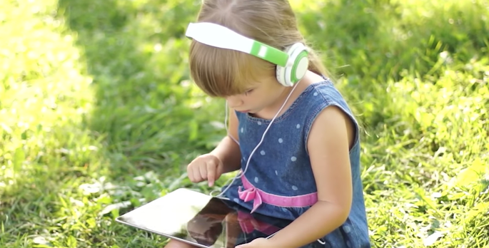 little girl playing with ipad