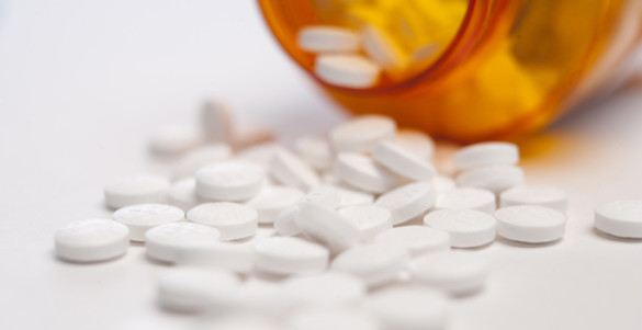 white pills spilling out of a prescription bottle