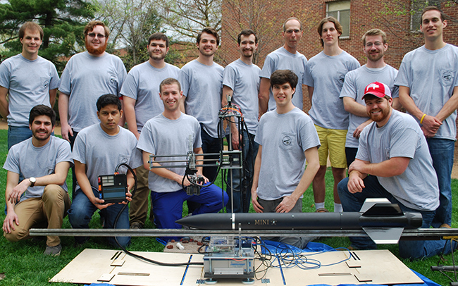 team posing with rocket