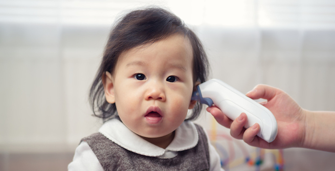 Asian baby girl getting temperature taken