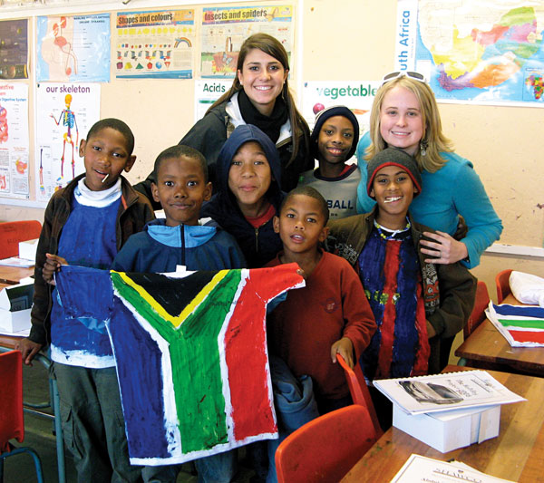 mankids1 HOD majors Christina Cacciatore, left, and Katie Klein with students from Manenburg Primary.