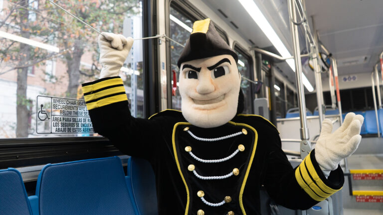 Mr. C riding a WeGo bus, pulling the stop cord to get off at the next bus stop.