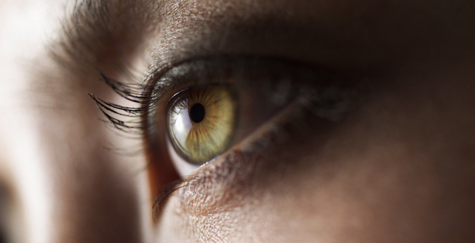 close up of medium skin toned woman's eye with hazel colored iris