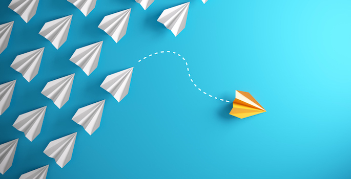 Group of paper plane in one direction and with one individual pointing in the different way, can be used leadership/individuality concepts.