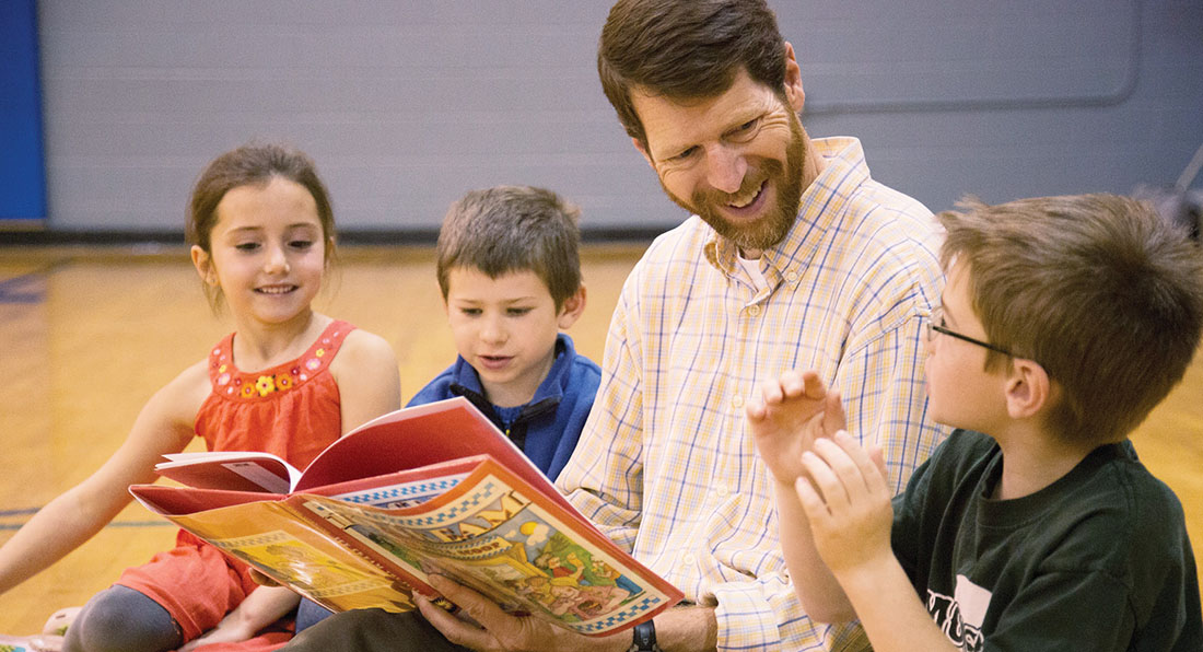 Photo of Duncan McDougall reading to children