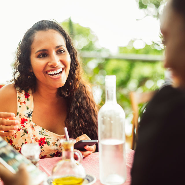 Two women sharing a meal at a restaurant booth.