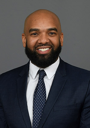 Alumni Asa Briggs in a suit and tie