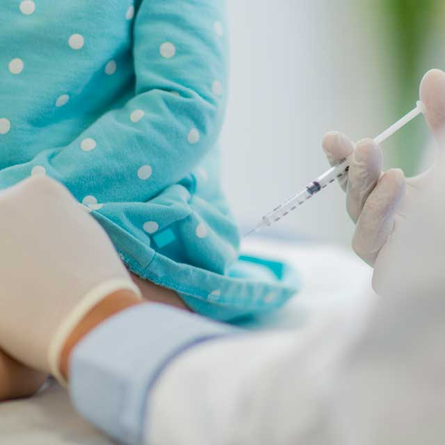 Child getting a flu shot from a medical professional.