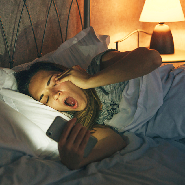 Woman in bed with phone