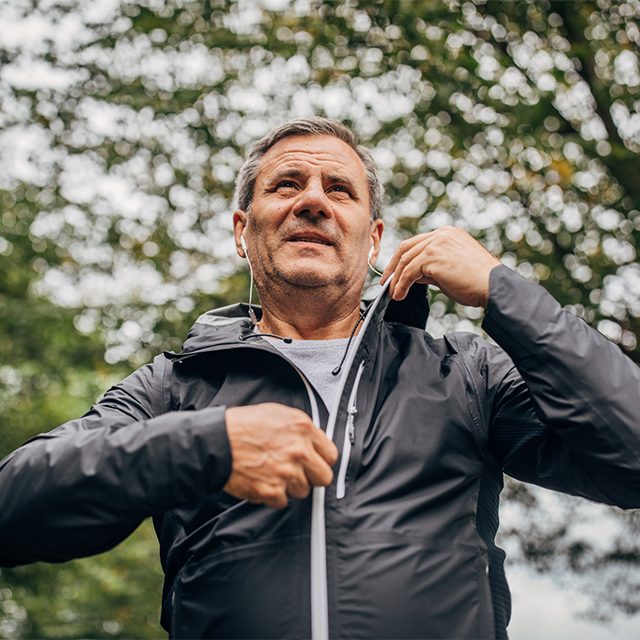 Older man zipping jacket outdoors