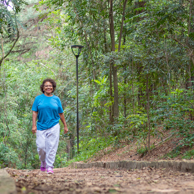 A woman walks alone along a path in the woods