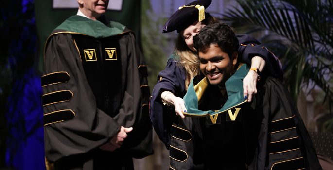 School of Medicine graduate Sai Chennupati receives his academic hood from Amy Fleming, MD, MScHPE.