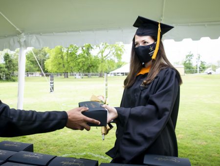 MSN graduate Karina Maza picks up her to-go box of strawberries and chocolates after commencement. Maza was a Spanish interpreter at VUMC before earning her MSN.