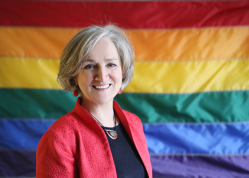 Columbia School of Nursing's Tonda Hughes in front of a rainbow flag