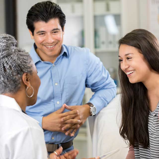 Man and woman speaking with primary care specialist.