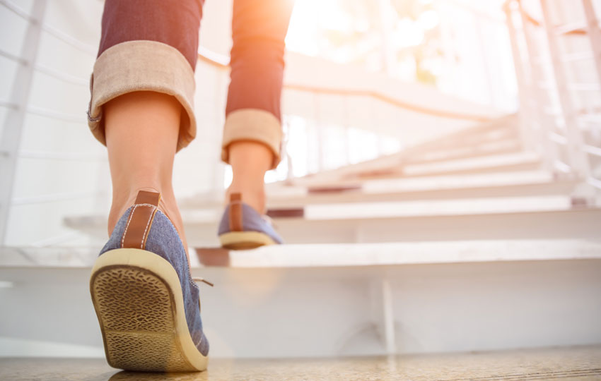 Image of woman walking and avoiding a sedentary lifestyle.