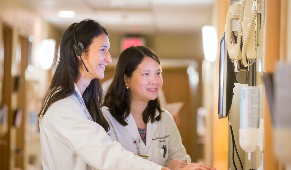 Doctors talking at a computer