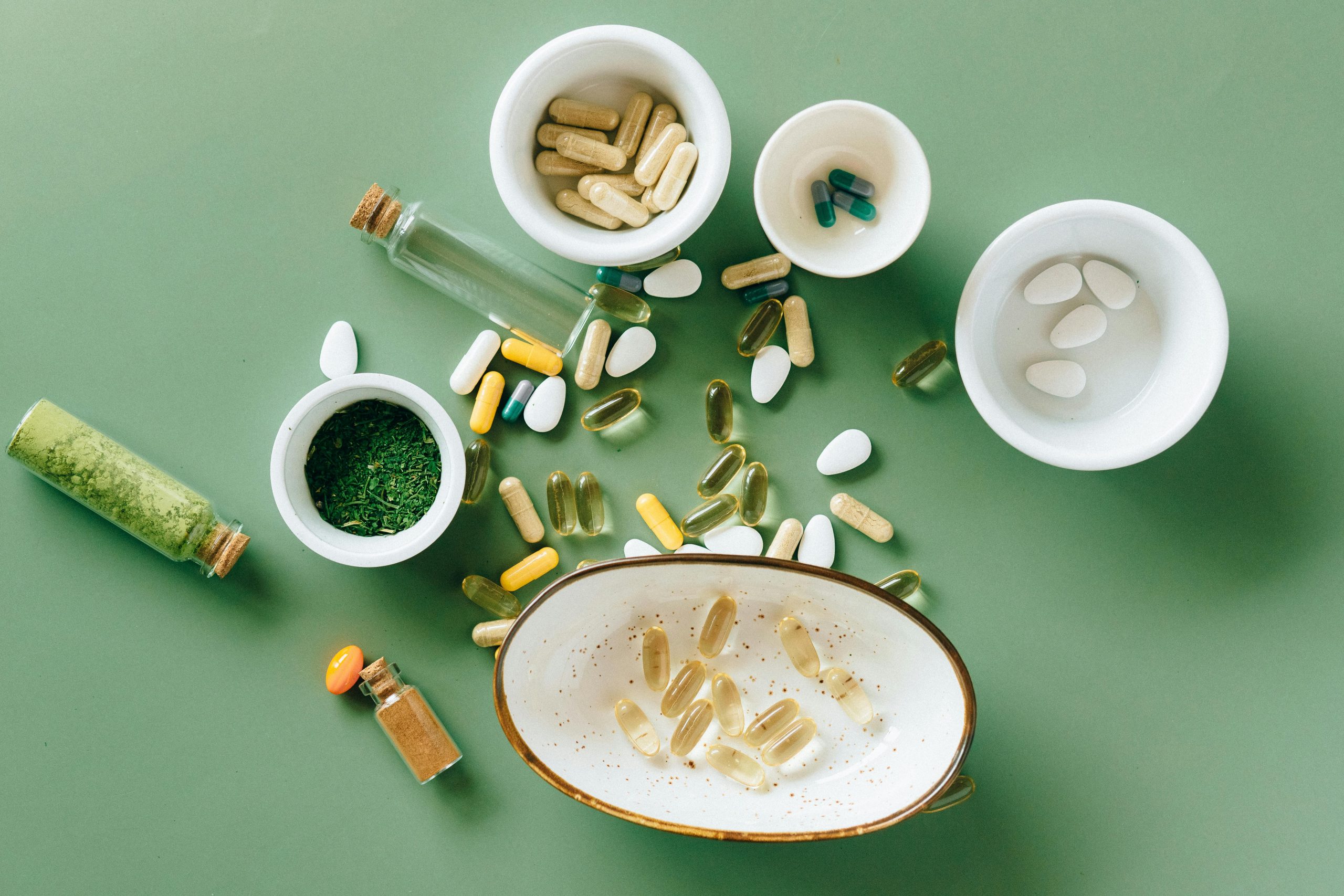 An assortment of alternative medicines and supplements in front of a green background.