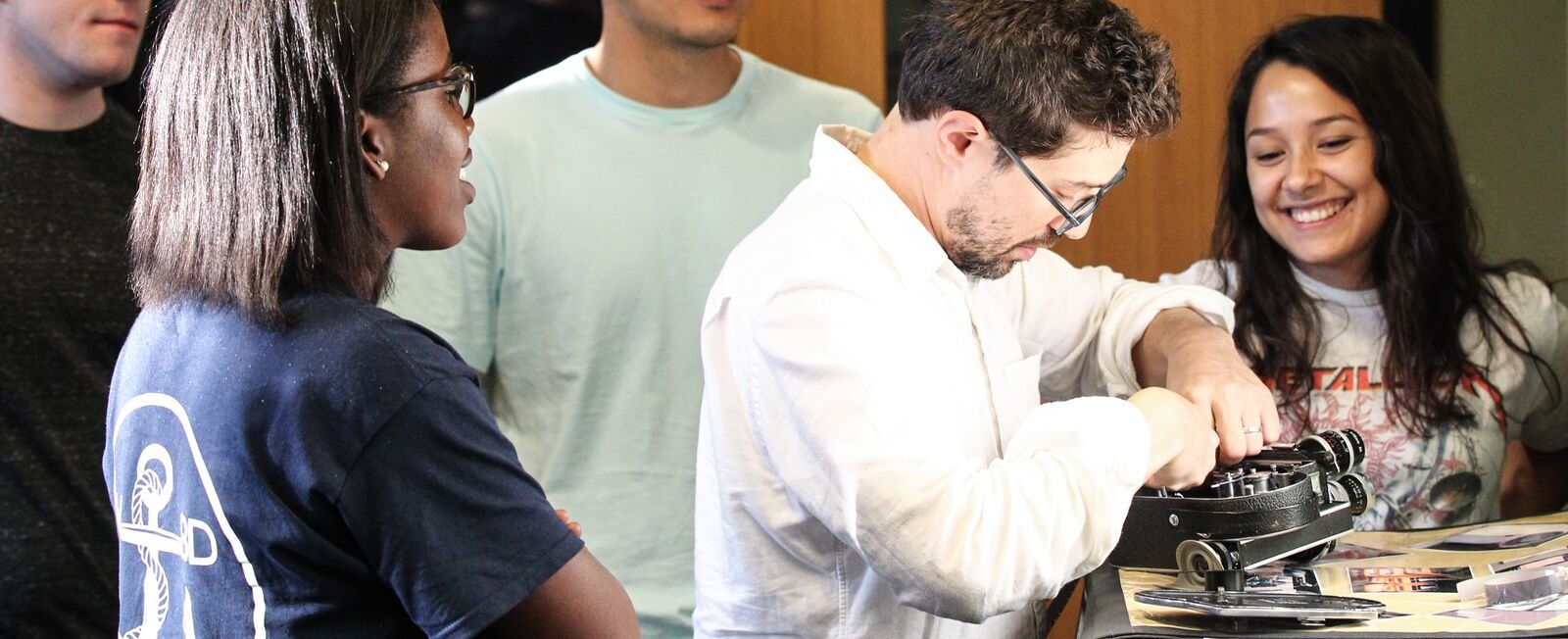 Prof Rattner demonstrates 16mm camera use to a group of 4 students